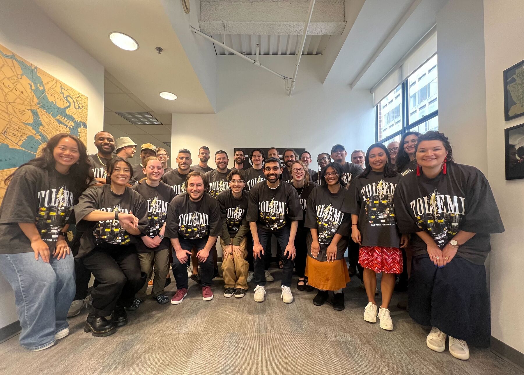 The whole Tolemi team in matching T-shirts at the Boston office