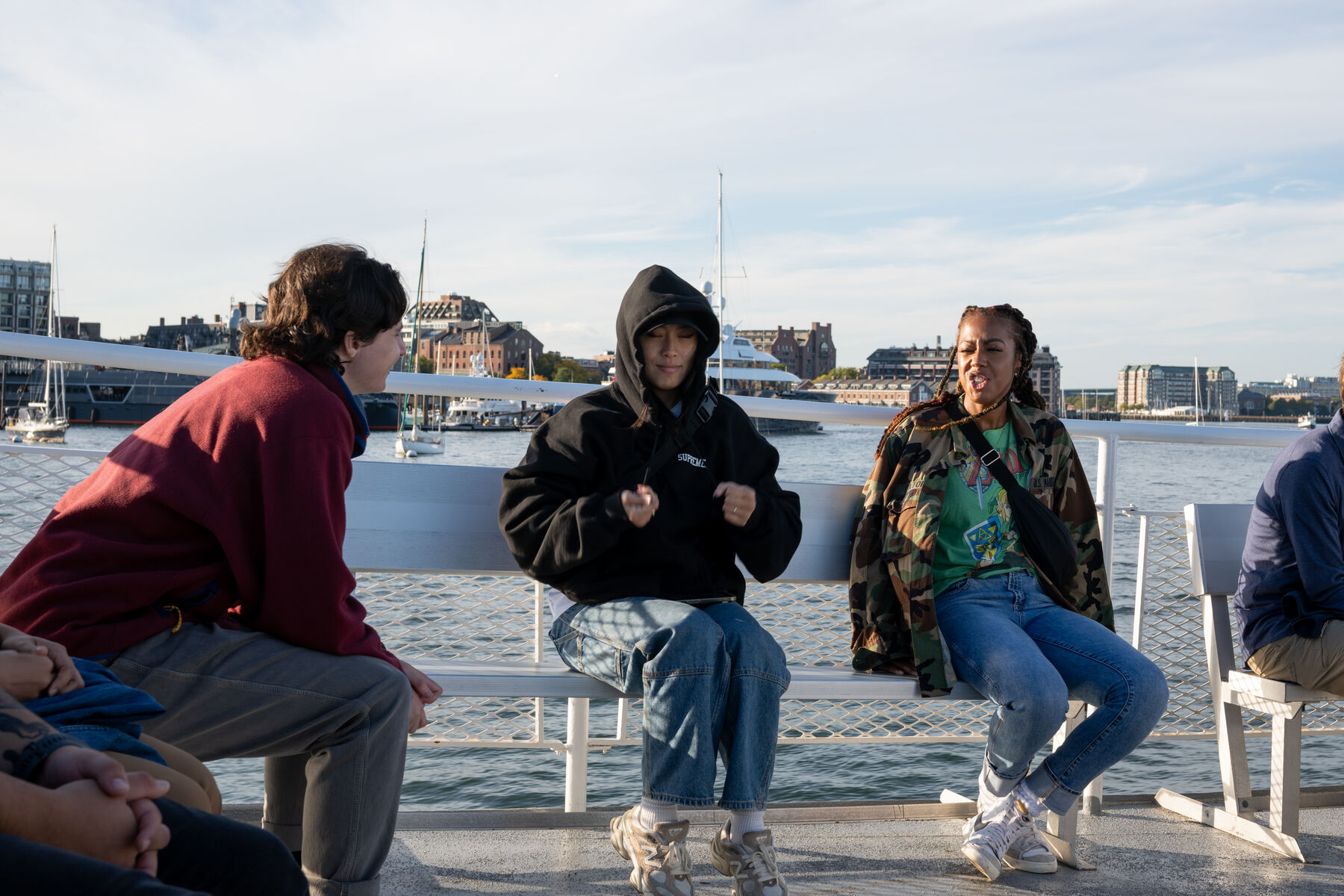 Three teammates chatting on a bench on a boat