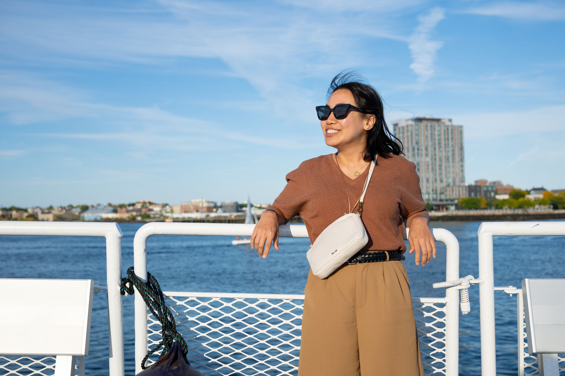 A teammate in sunglasses smiling at a boat railing