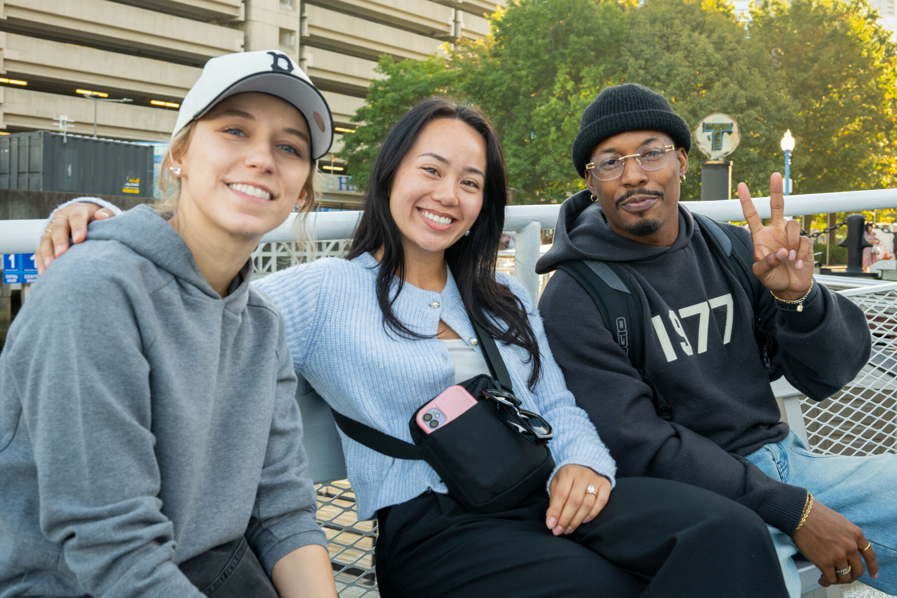 Three teammates smiling together on a boat