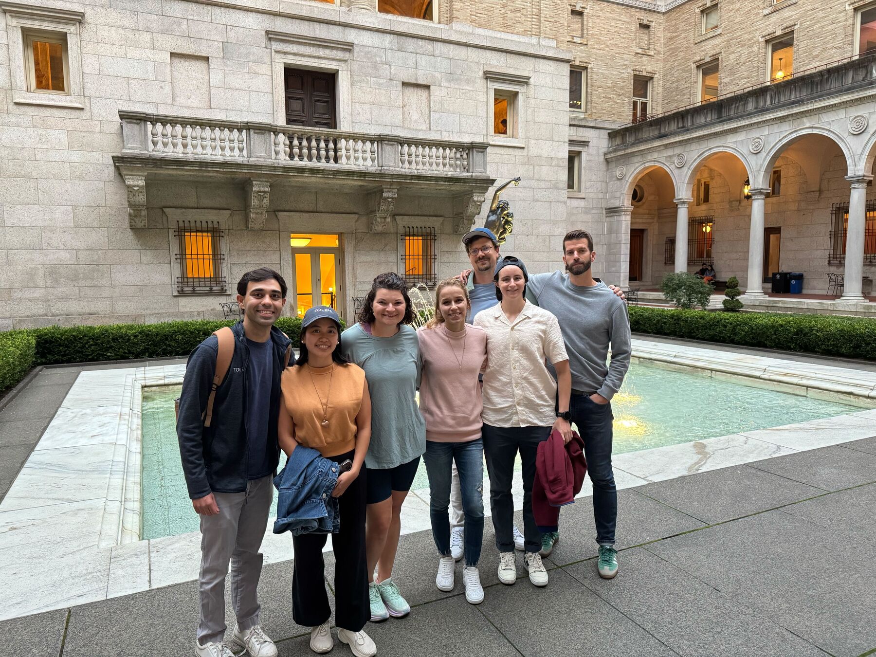 Teammates standing together in a library courtyard