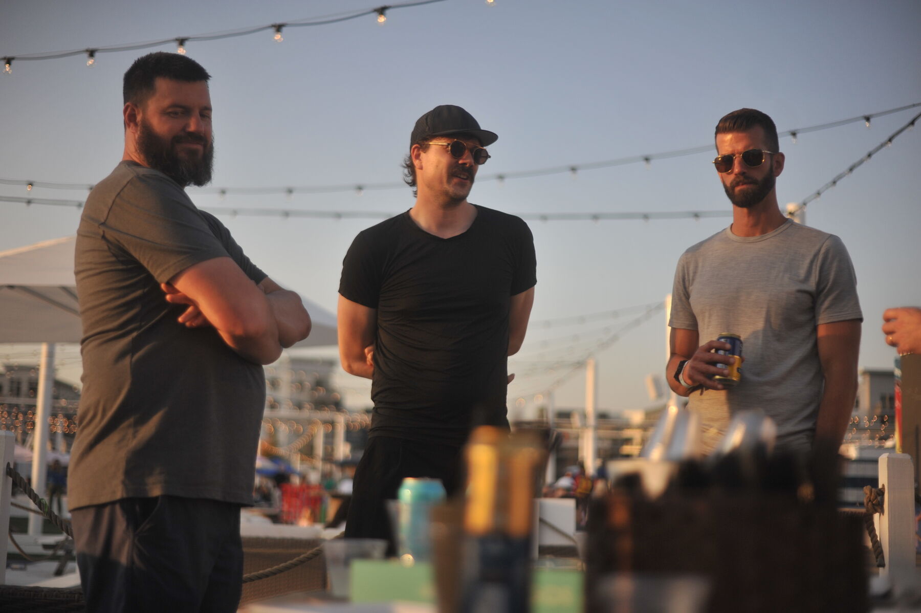 Three teammates talking on a rooftop at sunset